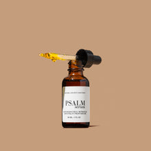 Load image into Gallery viewer, Brown glass bottle labeled 'Psalm Serum' with dropper on a beige background. Serum dripping out of dropper, serum is gold.